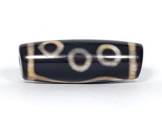 V-102723-6EBS Six Eye dzi bead, opposite angled end view, warm brown cap, pitch-black body, unretouched