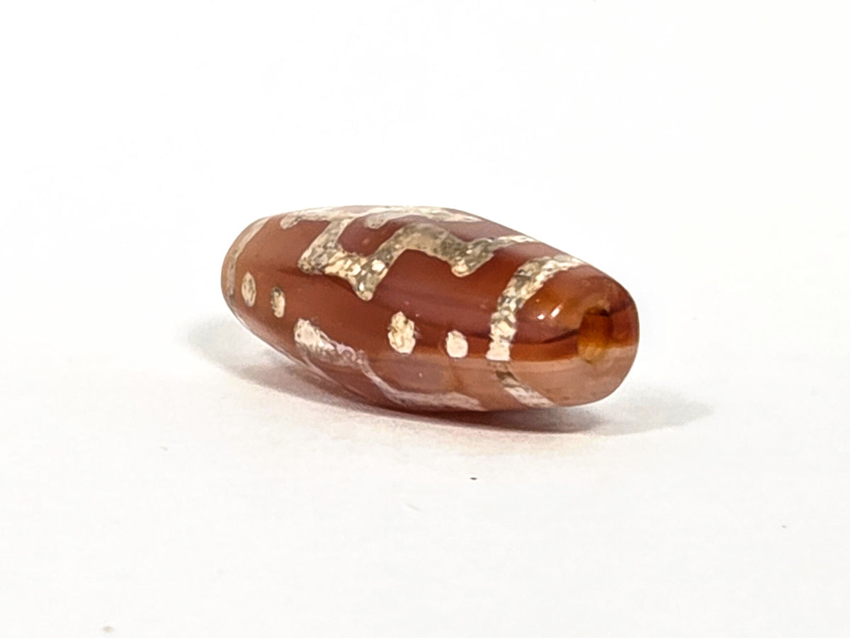 Ac-080426-DCCS ancient carnelian dzi bead 29.1×12.2mm, drill end view showing warm orange translucent carnelian, unretouched