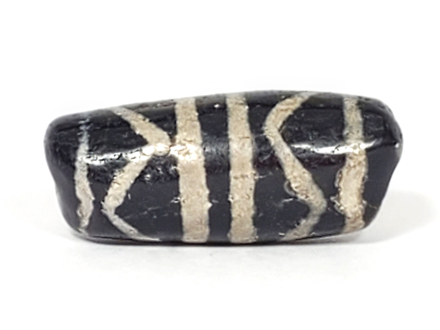 Close-up of Double Tiger Tooth motif etched on 500–800 year old genuine Tibetan Dzi bead