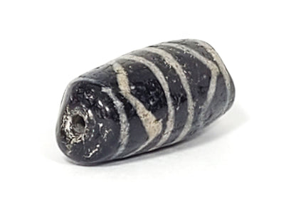 Drill hole end view of ancient Double Tiger Tooth Dzi bead showing natural agate patina and age
