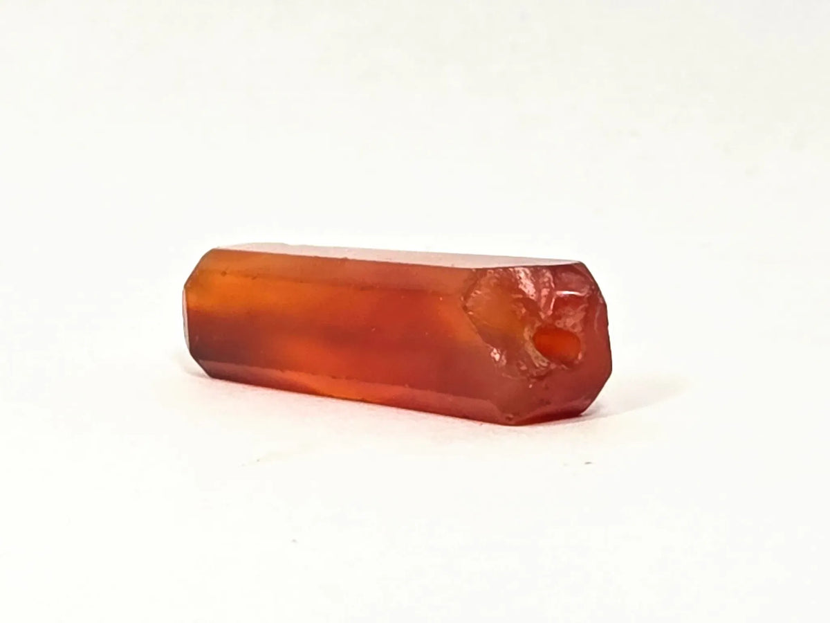 Ancient Indus Valley carnelian beveled bead, translucent orange-red, polished facets, visible drill hole, ancient chipping, 28mm