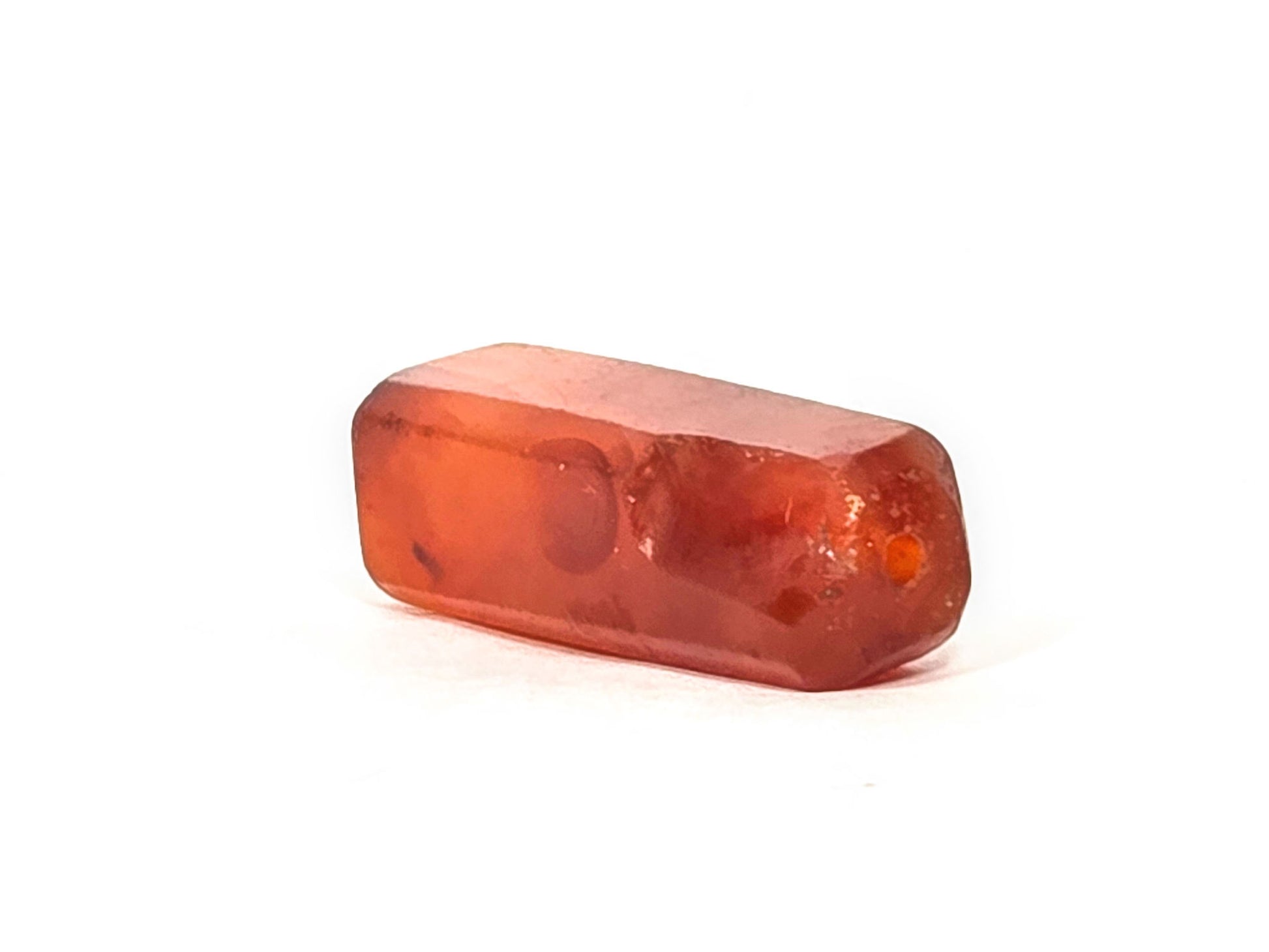 Ac-071026-CBEV2 ancient beveled carnelian angled view lesser-chipped drill end intact round hole unretouched