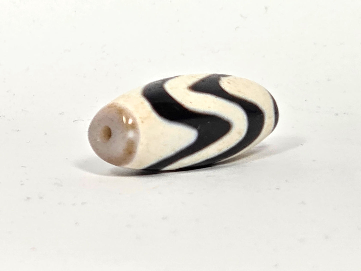 Ac-082524-DWBS, angled End B, warm grey-taupe end cap with drilled hole, brilliant white body, double wave motif, unretouched
