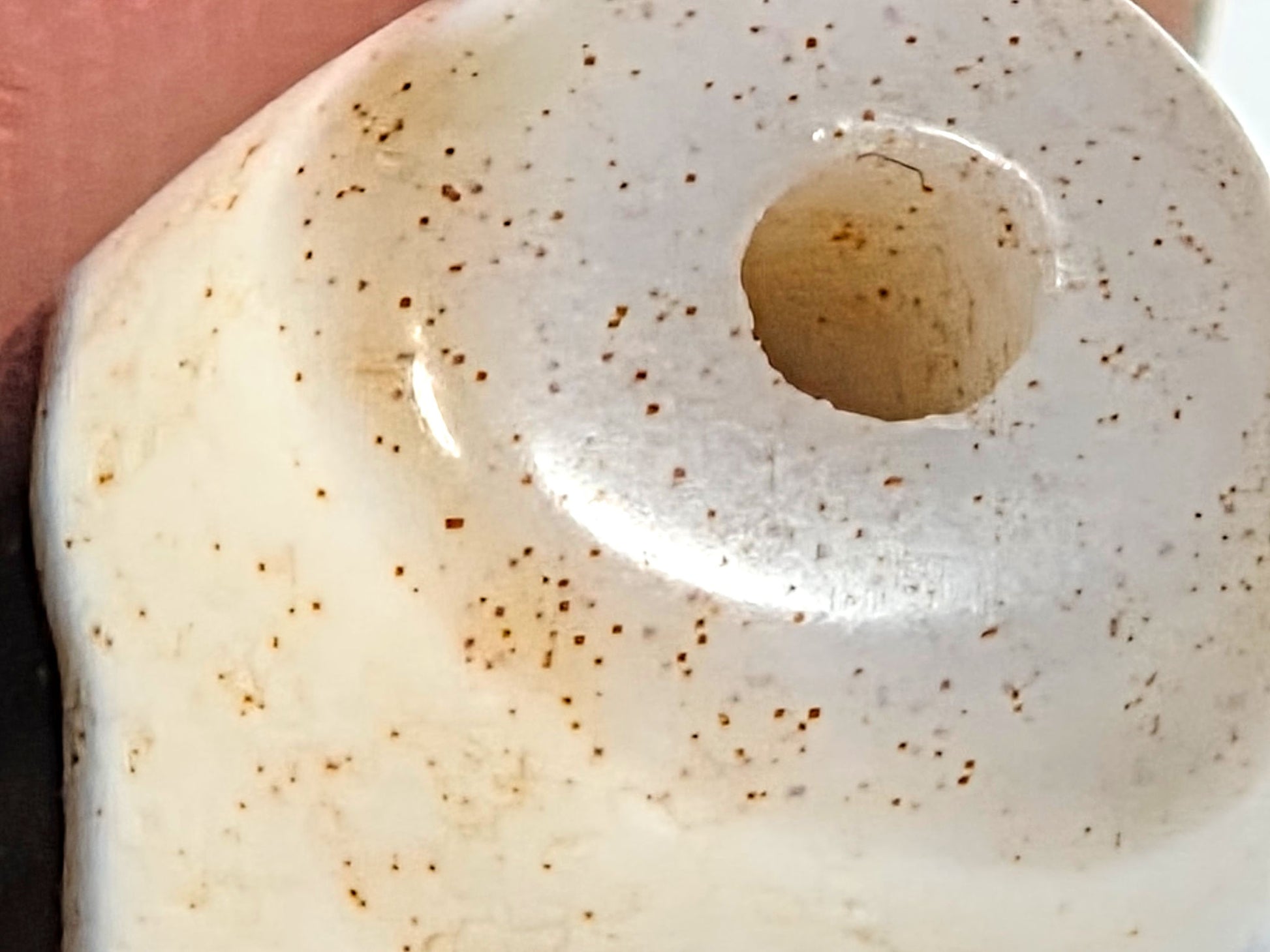 Ac-082524-DWBS, macro end cap zone showing dense cinnabar dot constellation and drilled hole interior, unretouched