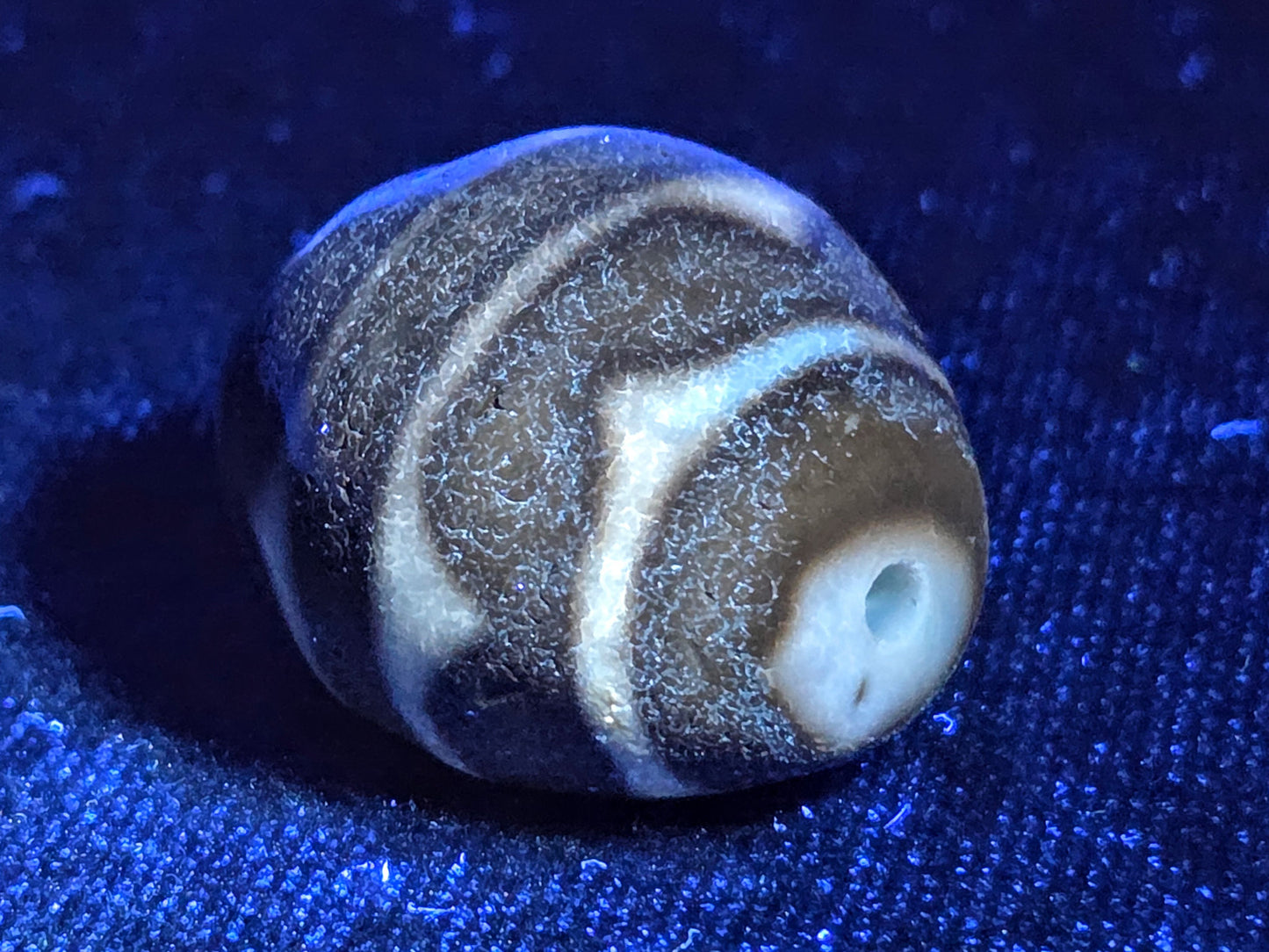 Ac-072326-RDW ancient round double wave dzi UV test drill end cream zone bright ancient agate response blue background