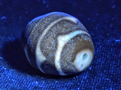 Ac-072326-RDW ancient round double wave dzi UV test drill end cream zone bright ancient agate response blue background