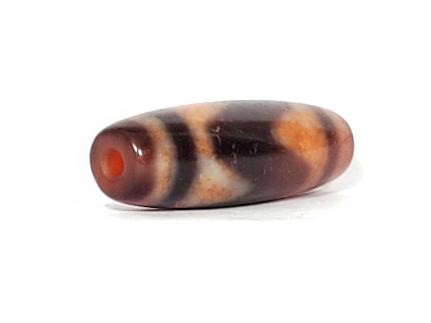 Ac-071026-TaBS ancient tasso dzi angled view drill end B orange-red end cap tasso chevrons visible unretouched