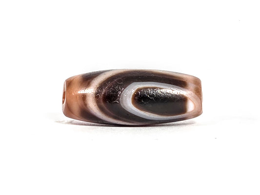 Two-eye dzi bead in warm reddish-brown agate with natural striping and polished surface