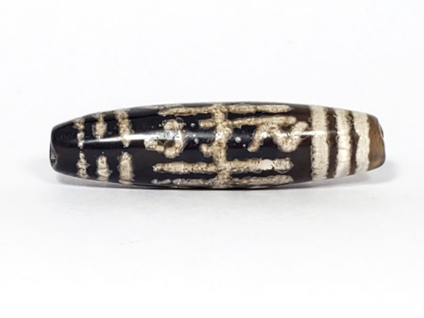 Second face of antique Waves & Bars Dzi — zigzag wave pattern and bar stripes on black agate