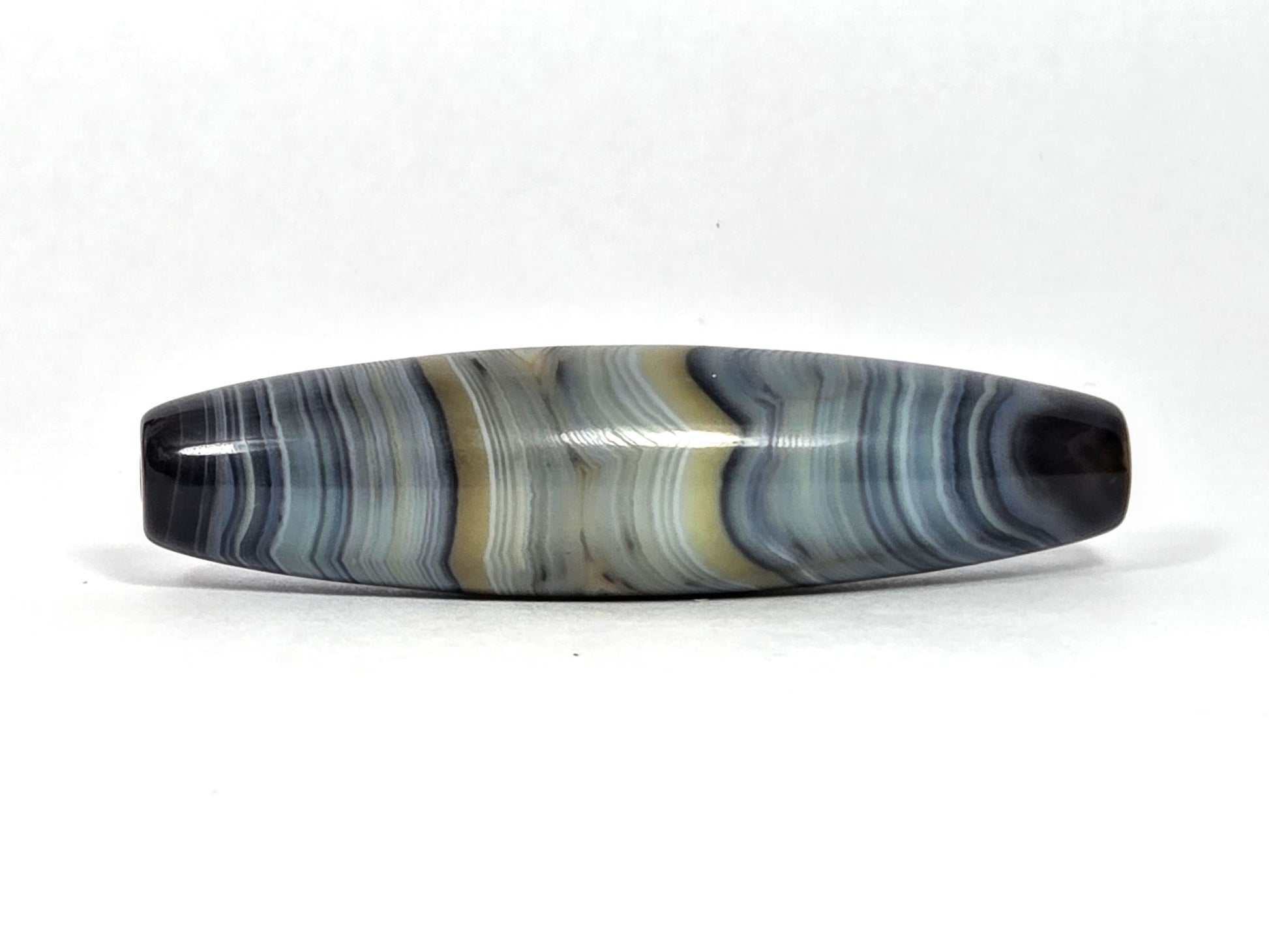 At-N-080426-1E2 antique natural one eye dzi bead 59.3×15.2mm, turn view showing cream and white bands prominent with warm zone receding, unretouched