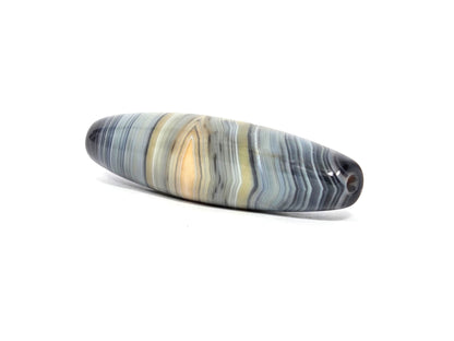 At-N-080426-1E2 antique natural one eye dzi bead 59.3×15.2mm, angled side view showing warm gold eye with orange core in blue-grey banding, unretouched