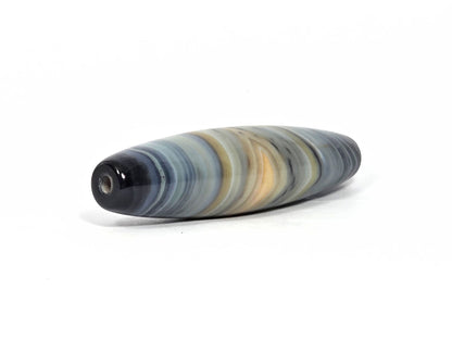At-N-080426-1E2 antique natural one eye dzi bead 59.3×15.2mm, angled drill-end view showing near-black tip, drill hole, and banding radiating outward, unretouched