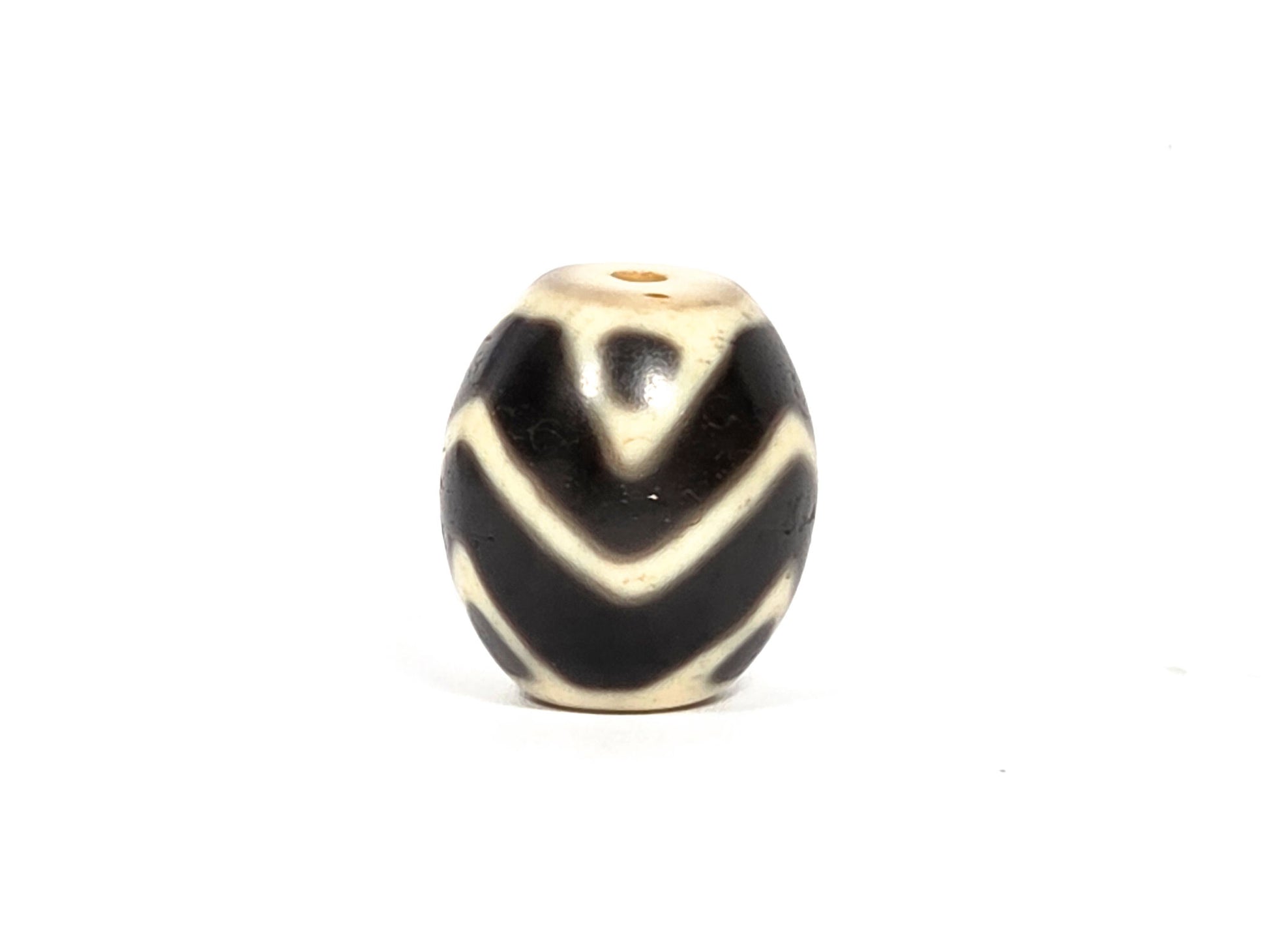 At-080926-WTT antique round Wave Tiger Tooth dzi bead 17.8×15.6mm, rotation C showing tiger tooth upper zone, broader arc chevrons, and age surface texture in cream zones, unretouched