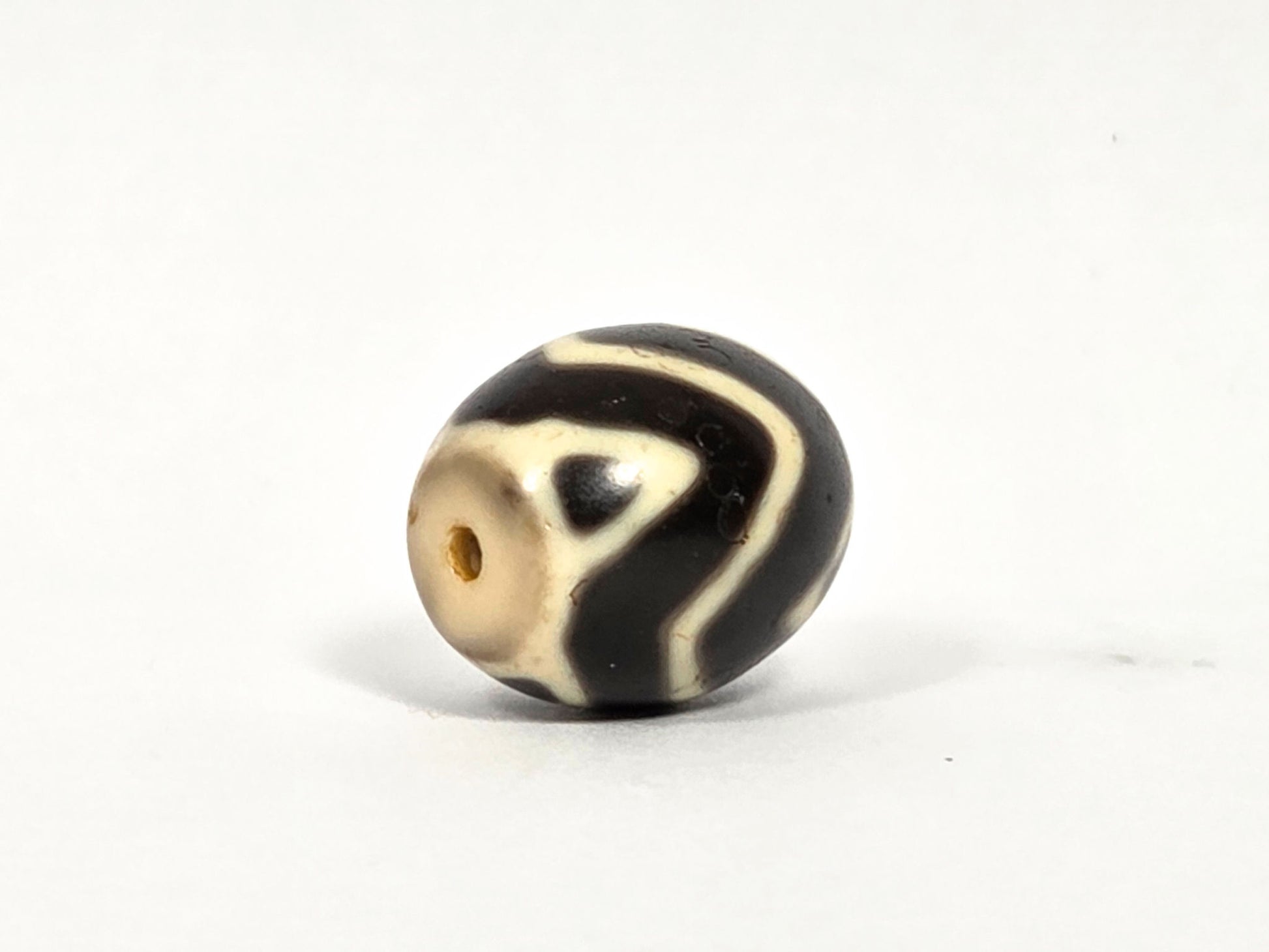 At-080926-WTT antique round Wave Tiger Tooth dzi bead 17.8×15.6mm, equatorial side rotation showing flowing wave lines and cream drill-end oval with warm honey agate interior, unretouched