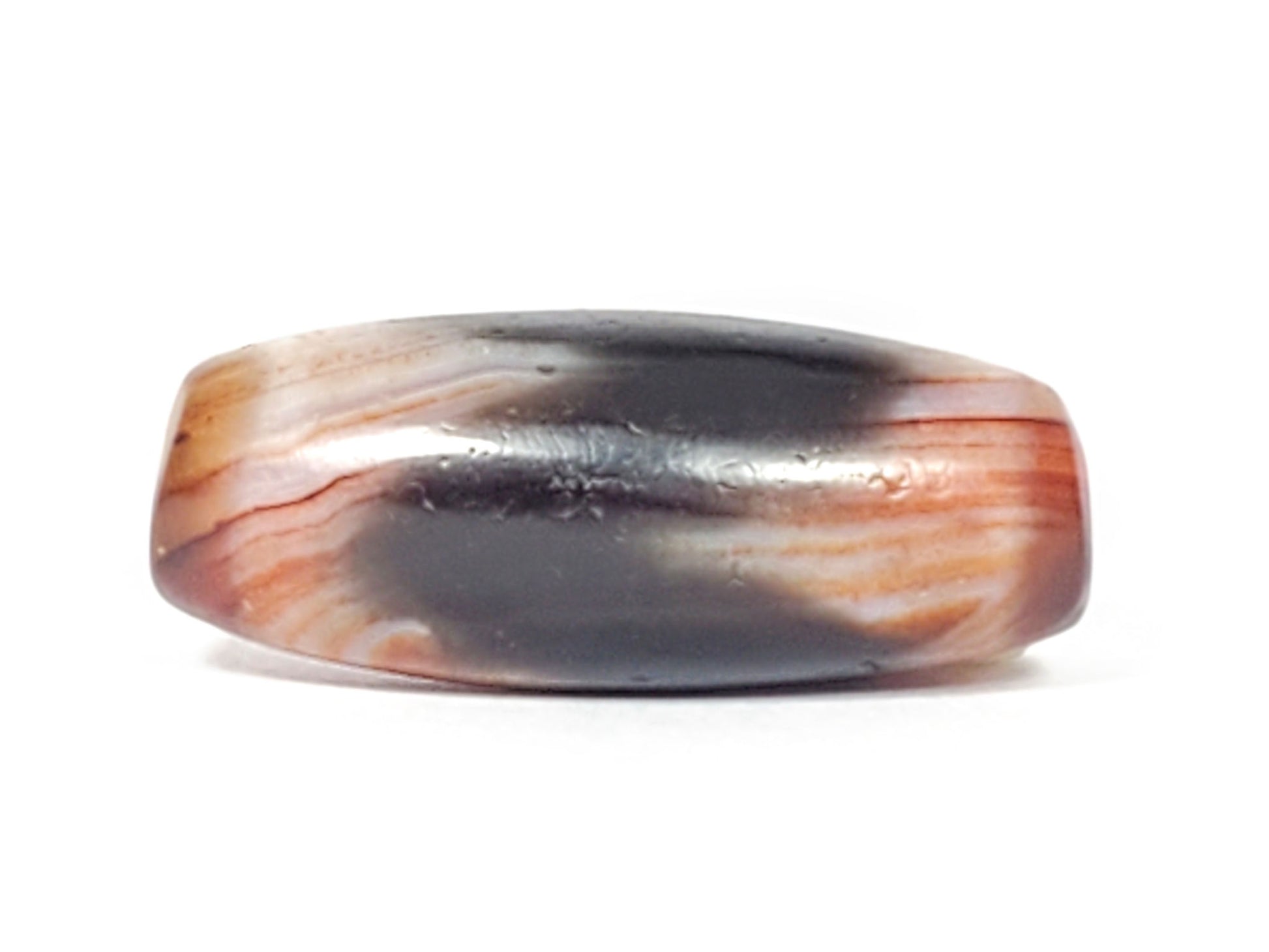 Top profile of antique Tasso dzi bead showing dark grey-black surface with fine weathering marks, At-052526-TaBS
