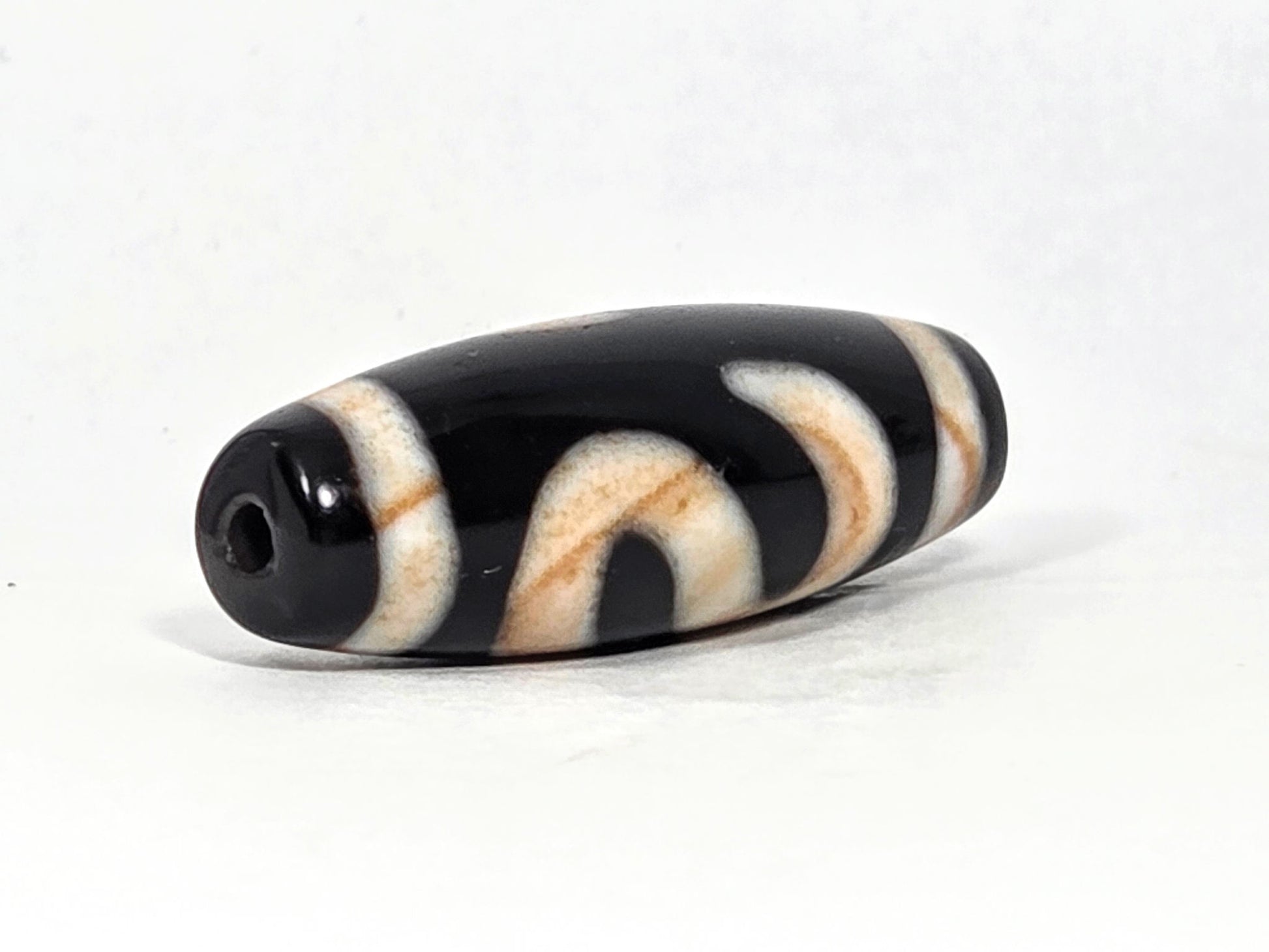 At-070726-MHBS antique money hook dzi bead opposite drill end angled view pitch-black agate fusiform profile unretouched