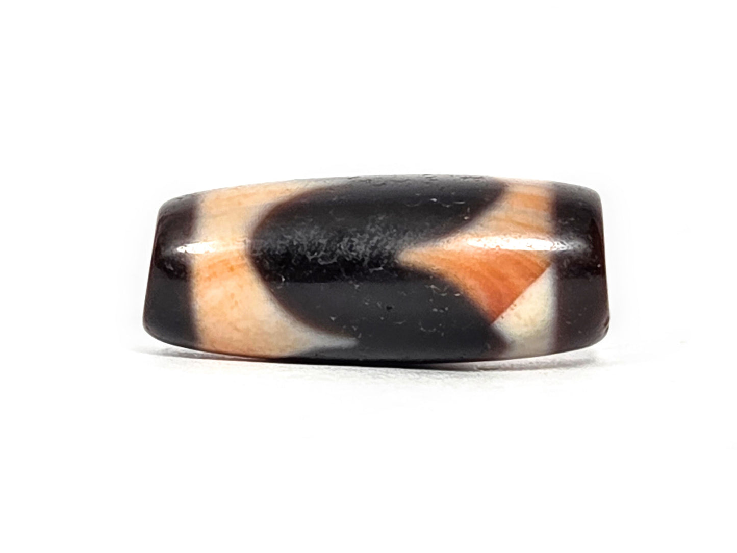 At-071426-TaBS4 Tasso bloodspot face B — opposing chevron form, pitch-black and warm cream-orange, unretouched.
