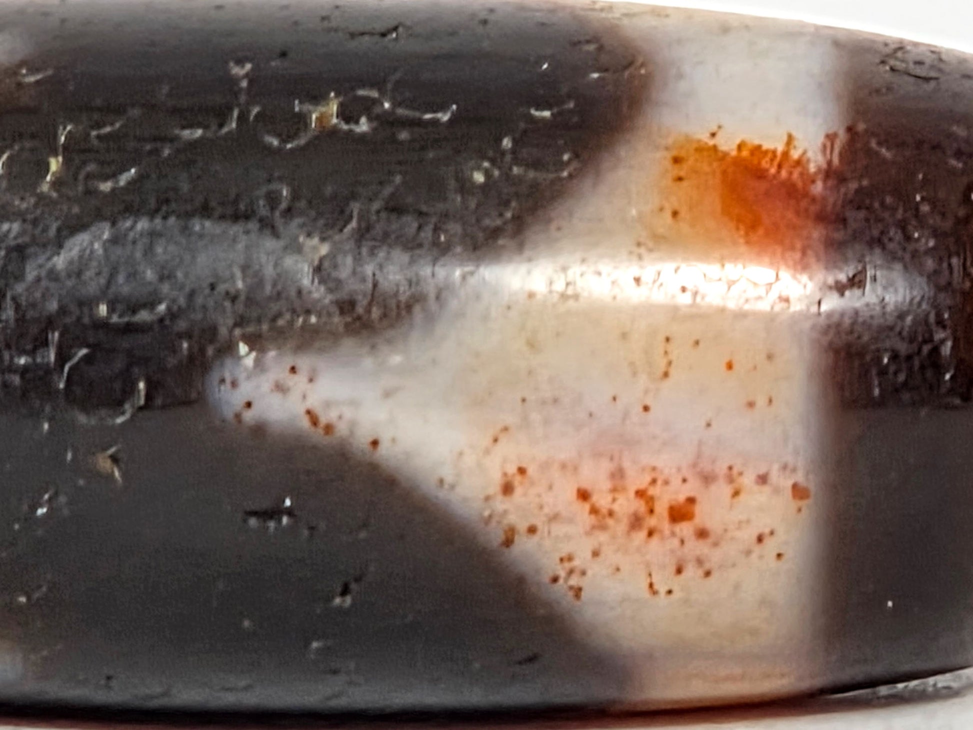At-071426-TaBS4 macro 1 — concentrated orange-red cinnabar saturation zone at motif centre, Tier 3 bloodspots, unretouched.