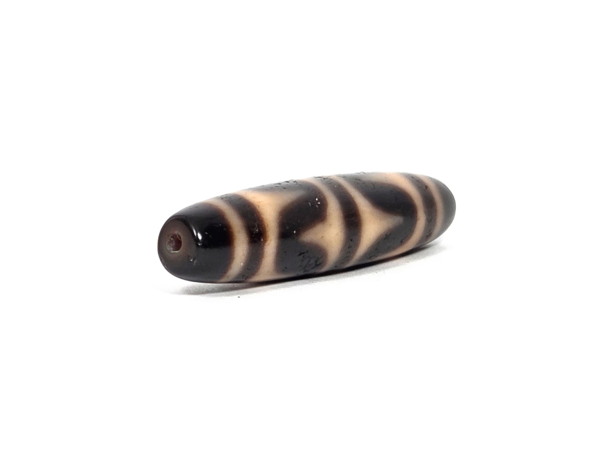 At-090226-DW6 antique double wave dzi dark agate, angled view opposite drill end wave band detail, unretouched