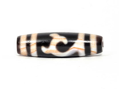 Antique Tibetan Green Tara Dzi bead, 200+ years old, 39.9mm × 11.7mm — Side A showing Green Tara motif on deep black and warm ivory natural agate with orange striations — unretouched photo — Ancient Dzi Shop