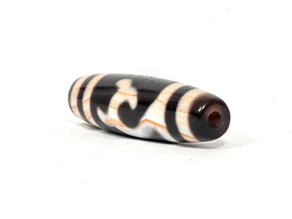 Angled view of antique Tibetan Green Tara Dzi bead showing drill hole end and natural agate taper — 39.9mm × 11.7mm — unretouched photo — Ancient Dzi Shop