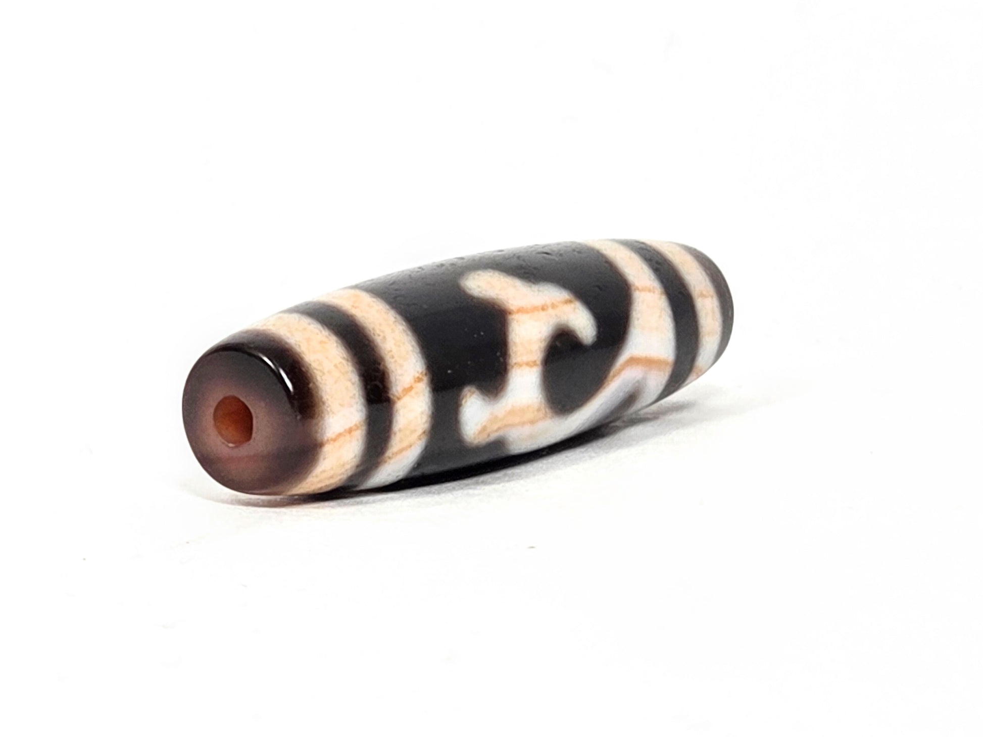 Antique Tibetan Green Tara Dzi bead — second drill hole end showing natural agate cap with warm amber patina and authentic surface — unretouched photo — Ancient Dzi Shop