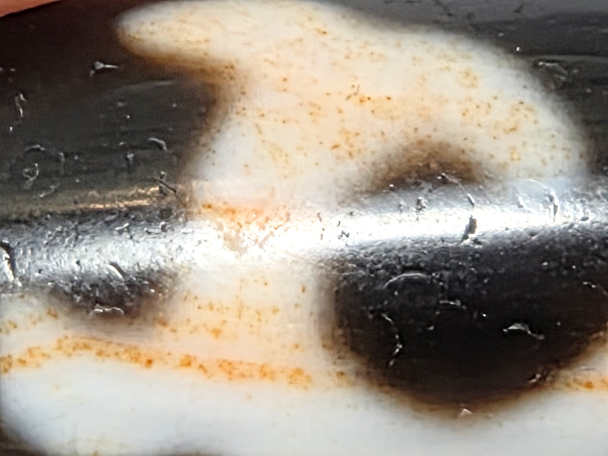 Extreme macro of antique Tibetan Green Tara Dzi bead showing natural cinnabar bloodspot specks and amber striations running through white agate field — 硃砂 zhūshā — unretouched photo — Ancient Dzi Shop