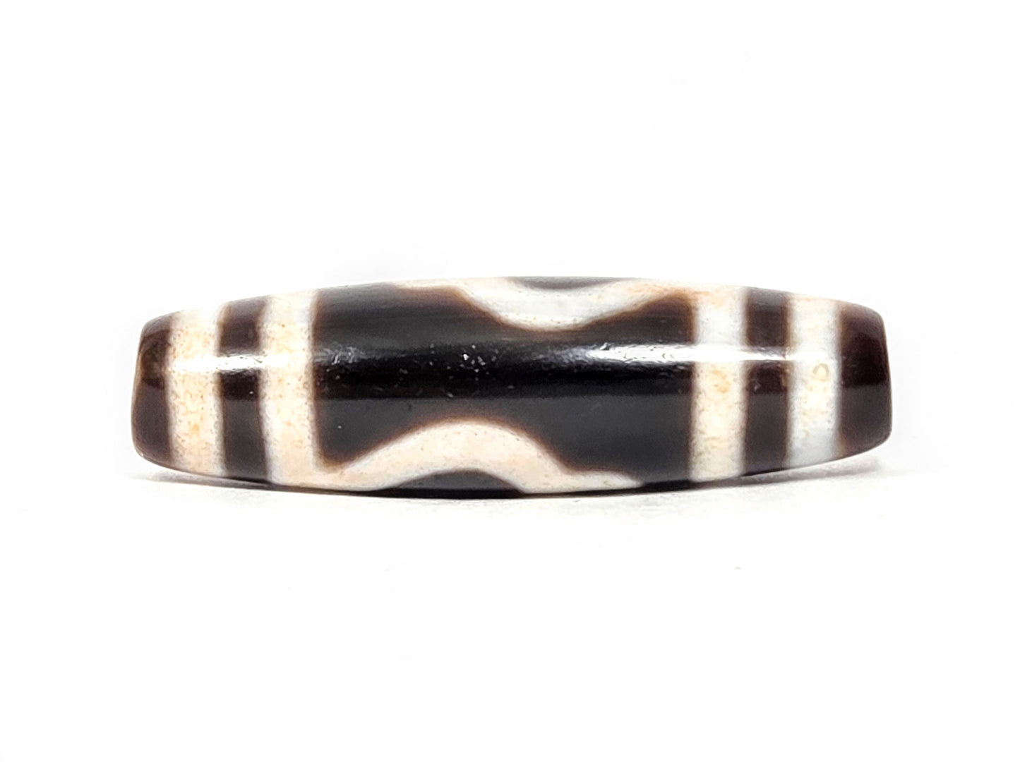 At-043026-GT connector face, paired cream wave lines on dark chocolate-brown agate, unretouched