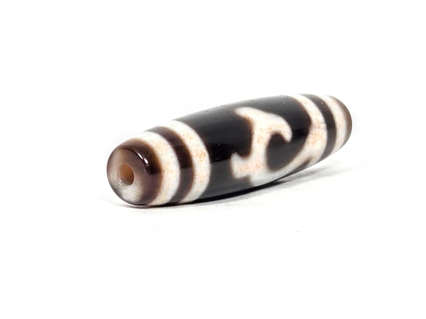  At-043026-GT End B, warm medium brown end cap, clean drill hole, cream Tara motif visible on body, unretouched