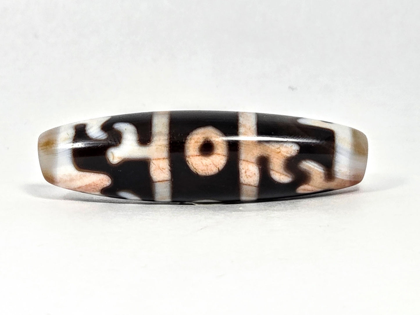 At-070626-GRRP3EBS rotated face 2, Guru Rinpoche three-eye dzi, pitch-black ground, cream-white & peach motif, unretouched