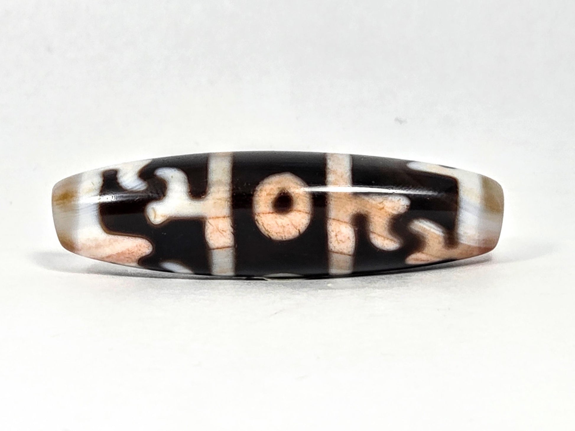 At-070626-GRRP3EBS rotated face 2, Guru Rinpoche three-eye dzi, pitch-black ground, cream-white & peach motif, unretouched