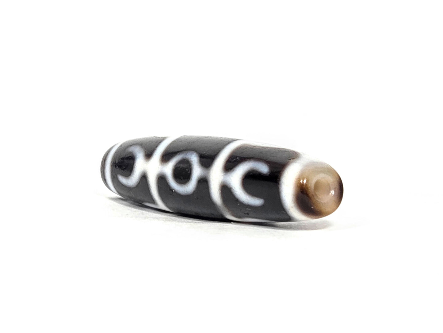 At-071426-GRS Guru Rinpoche Scepter end angle A — warm dark brown domed end cap, motif wrap visible, unretouched. 