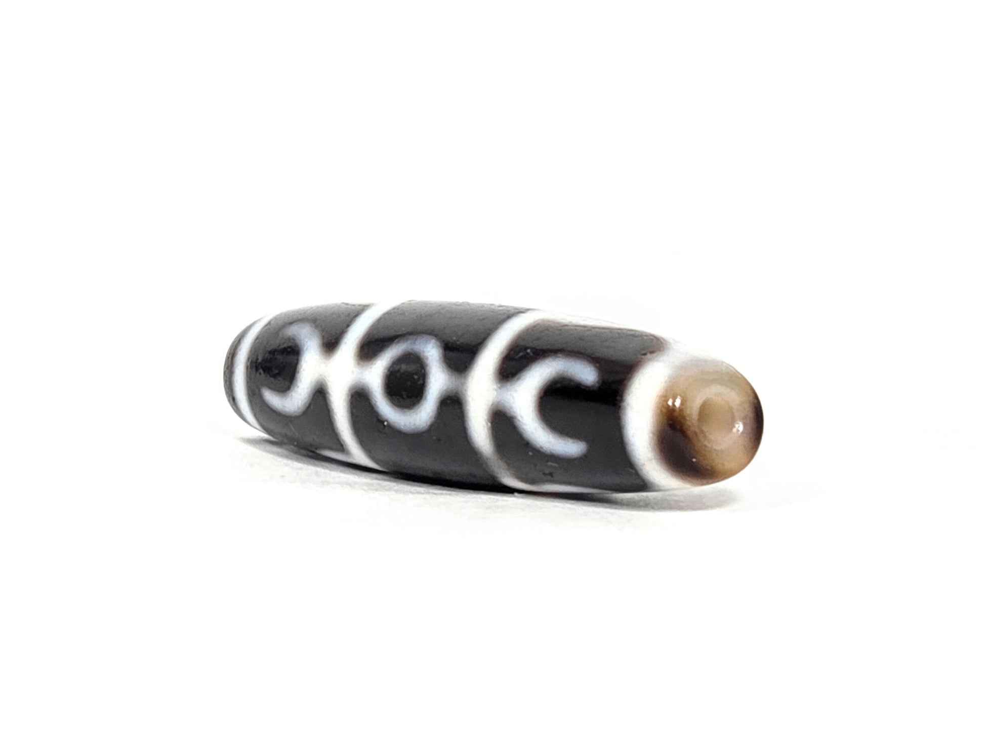 At-071426-GRS Guru Rinpoche Scepter end angle A — warm dark brown domed end cap, motif wrap visible, unretouched. 