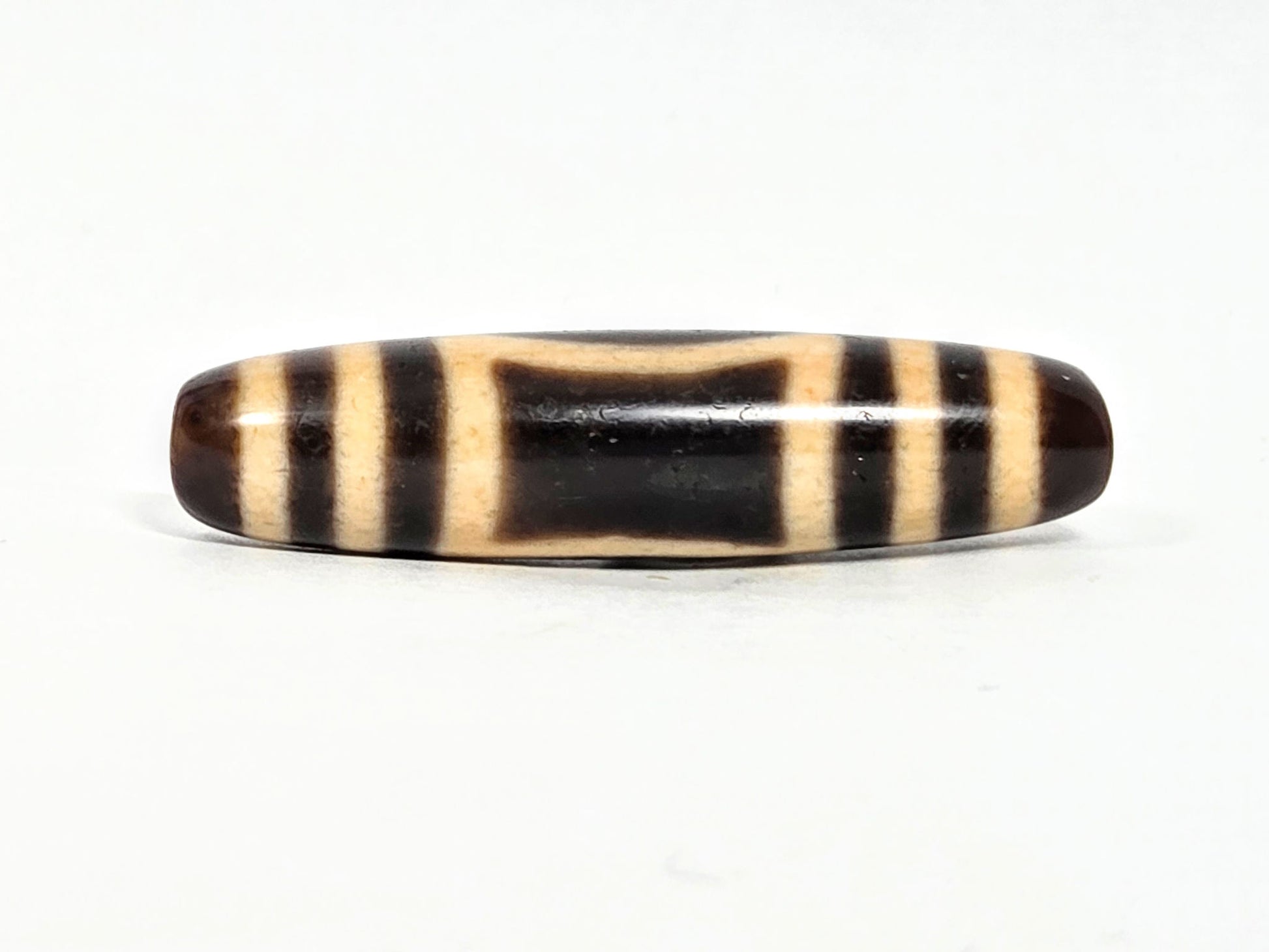At-071326-HE opposite face C, angular trapezoidal oval reading, warm honey-cream patina on bar zones, unretouched