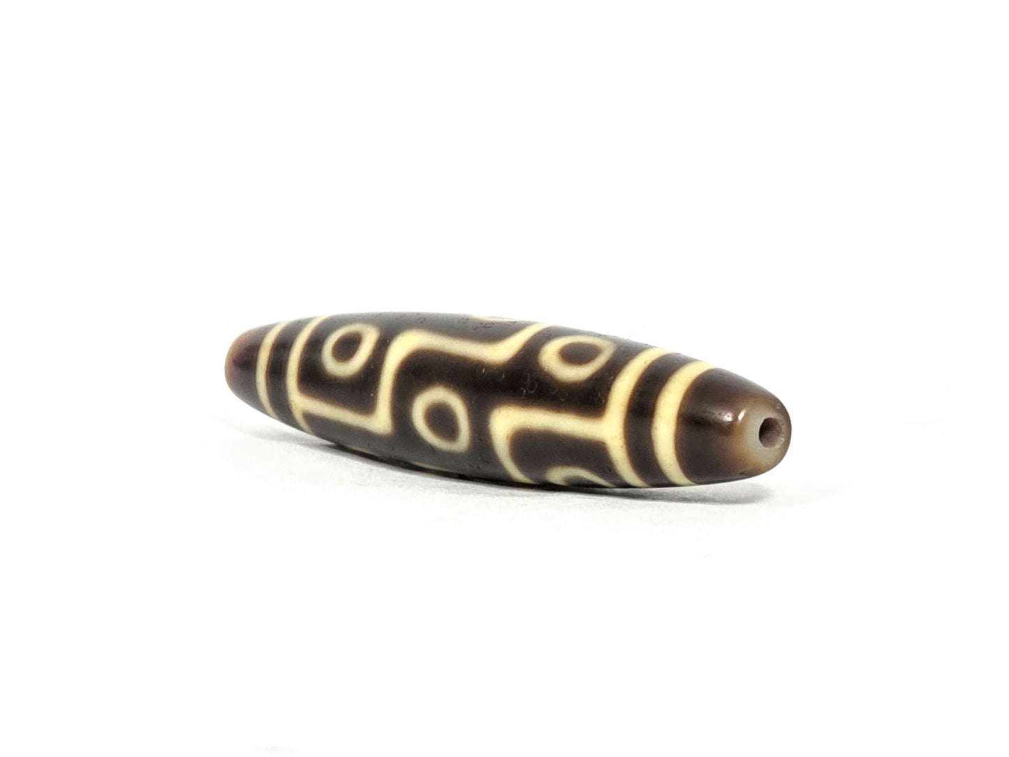 At-071126-9E8 sharp pointed drill-hole end, tip intact no chip, small centred hole, warm golden-brown taper, unretouched