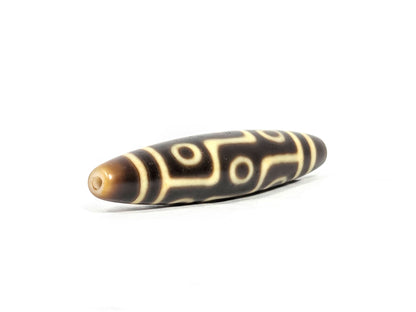 At-071126-9E8 rounded drill-hole end, warm honey-golden end cap, small centred hole, motif visible on body, unretouched