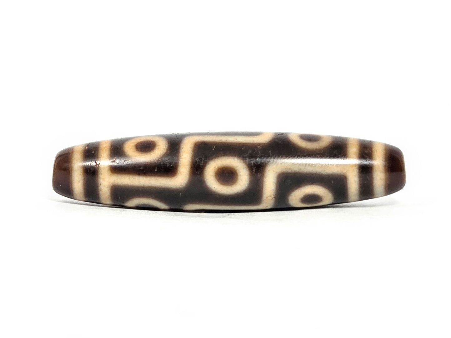 At-071326-9E face A, antique nine eye dzi 54.8×12.5mm, warm dark brown, honey-gold motif lines, 200–400 yrs, unretouched