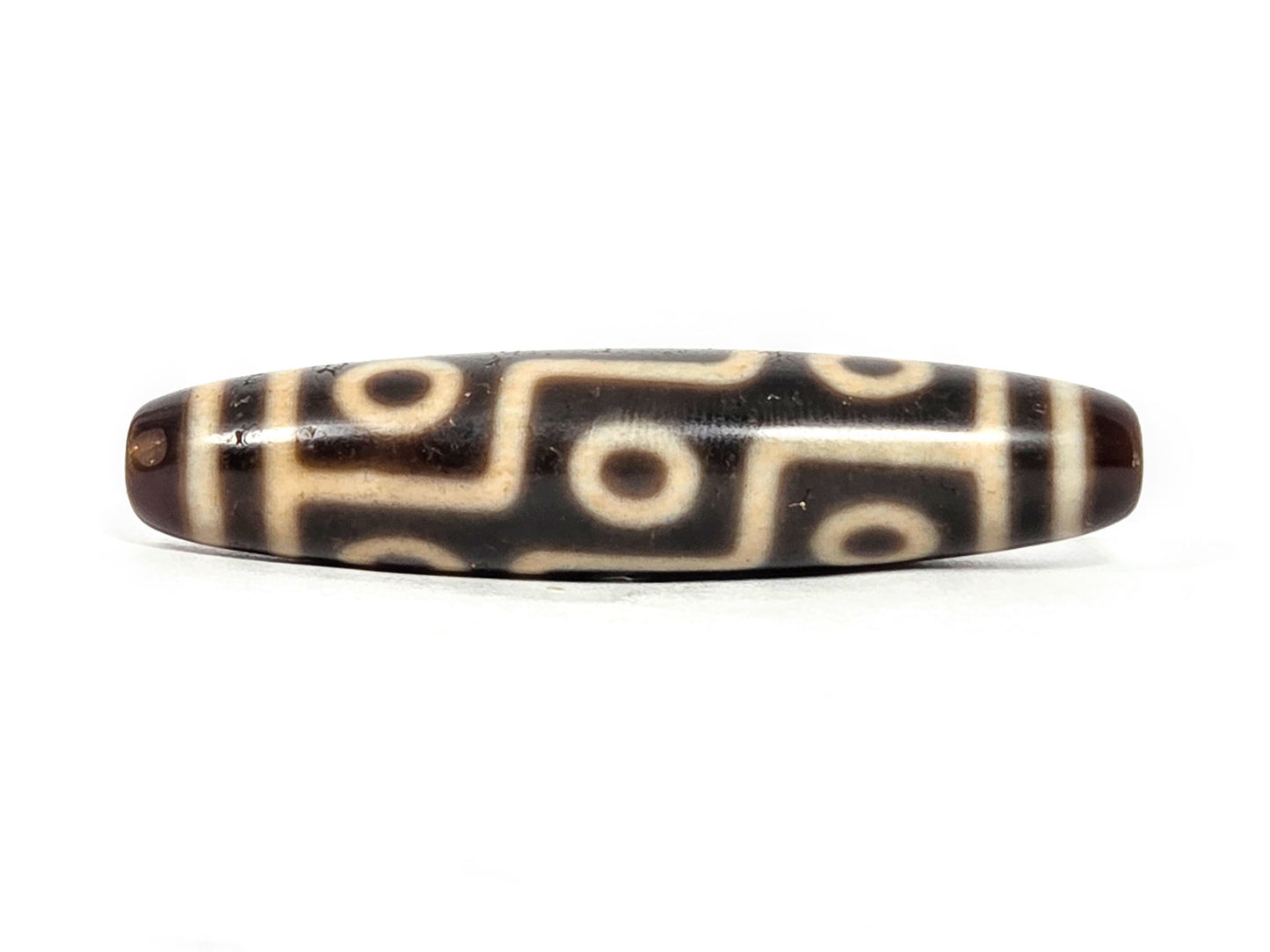 At-071326-9E face B, nine eye dzi, deeper warm dark brown, cream motif lines, stepped S-curve connectors, unretouched