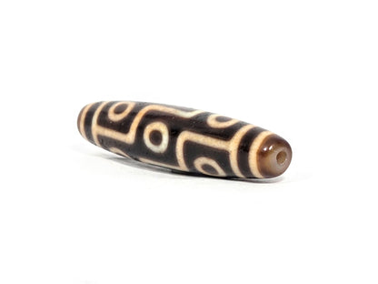 At-071326-9E2 three-quarter end, warm honey-golden cap, small drill hole, slender fusiform taper visible, unretouched