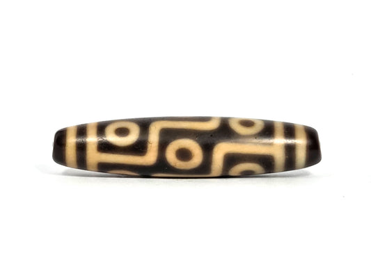 Nine-eye dzi bead, dark brown and cream agate with geometric eye motif pattern, polished surface