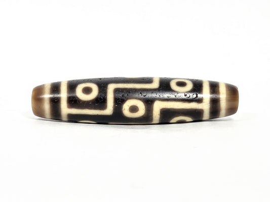 At-071126-9E7 face A, antique nine eye dzi 55.0×12.7mm, very deep dark brown agate, cool cream-white motif lines, unretouched