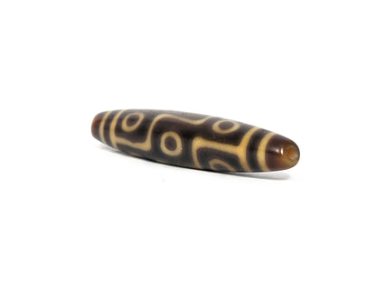 At-082326-9E antique nine eye dzi bead drill end view one warm honey-orange agate tip unretouched