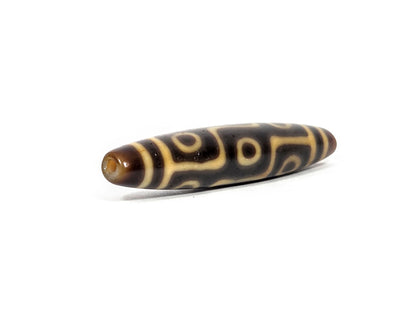At-082326-9E antique nine eye dzi bead drill end view two warm honey-orange tip elongated fusiform unretouched