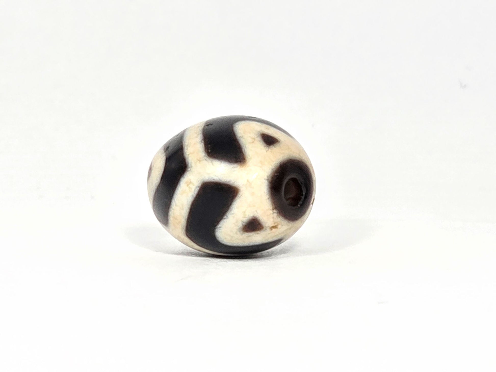 At-070826-RTTL antique round tiger tooth longevity dzi opposite drill-end view cream-ground dark motif wrap unretouched