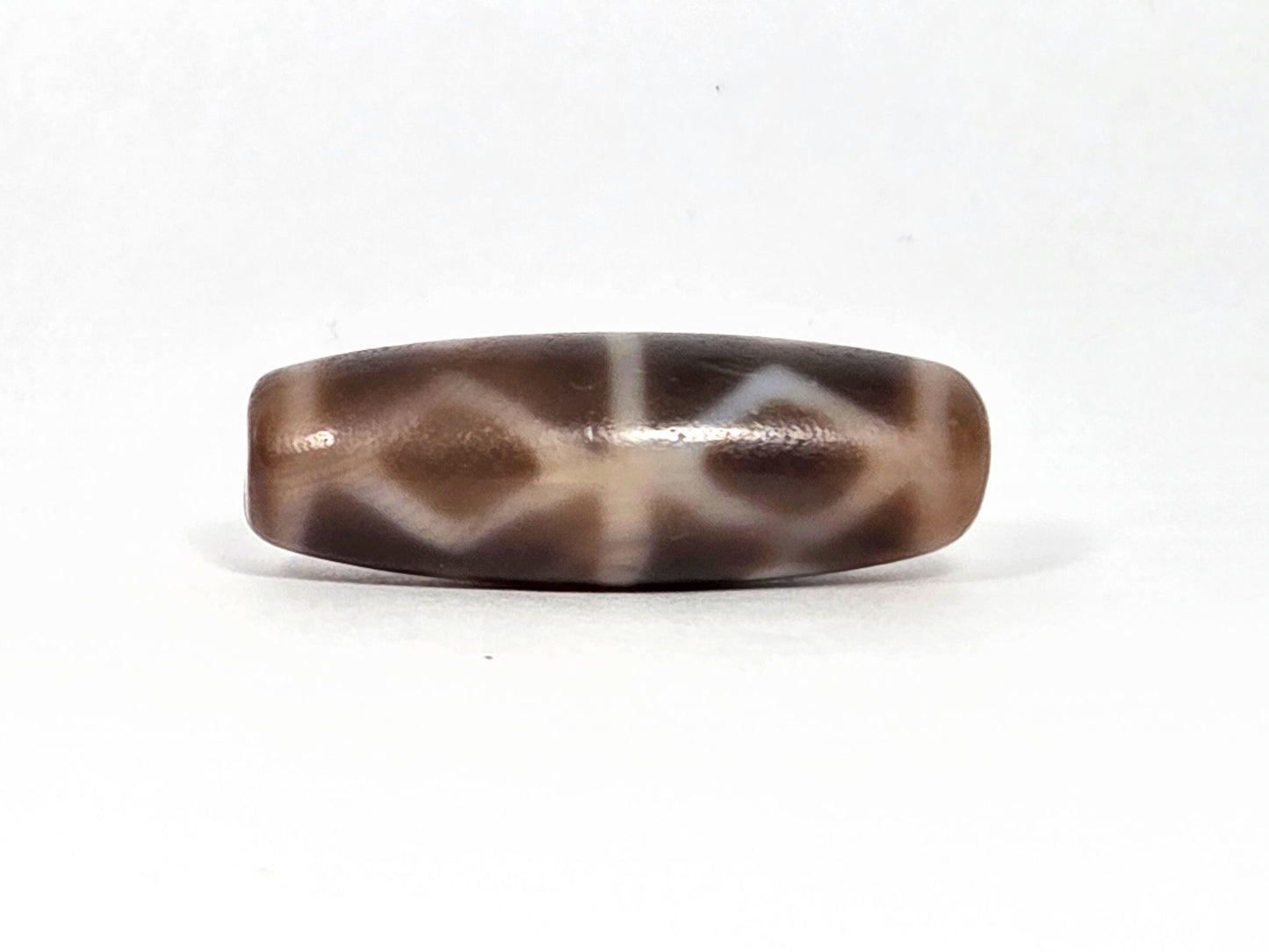 At-080926-6EDS2 antique Six Eye Diamond Spear dzi bead 33.0×11.5mm, Face B showing three diamond forms with slightly compressed profile, warm brown ground, unretouched
