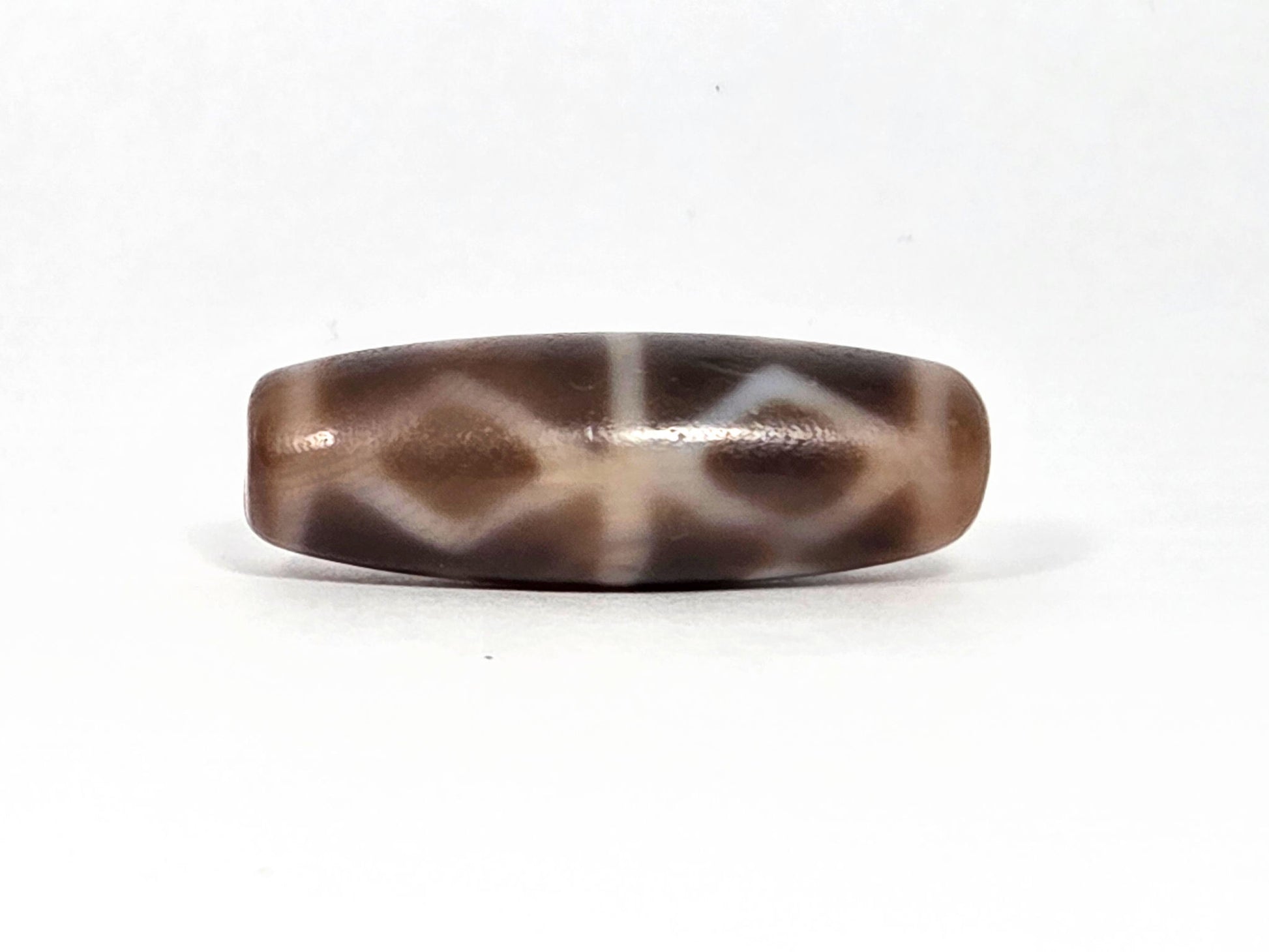At-080926-6EDS2 antique Six Eye Diamond Spear dzi bead 33.0×11.5mm, Face B showing three diamond forms with slightly compressed profile, warm brown ground, unretouched
