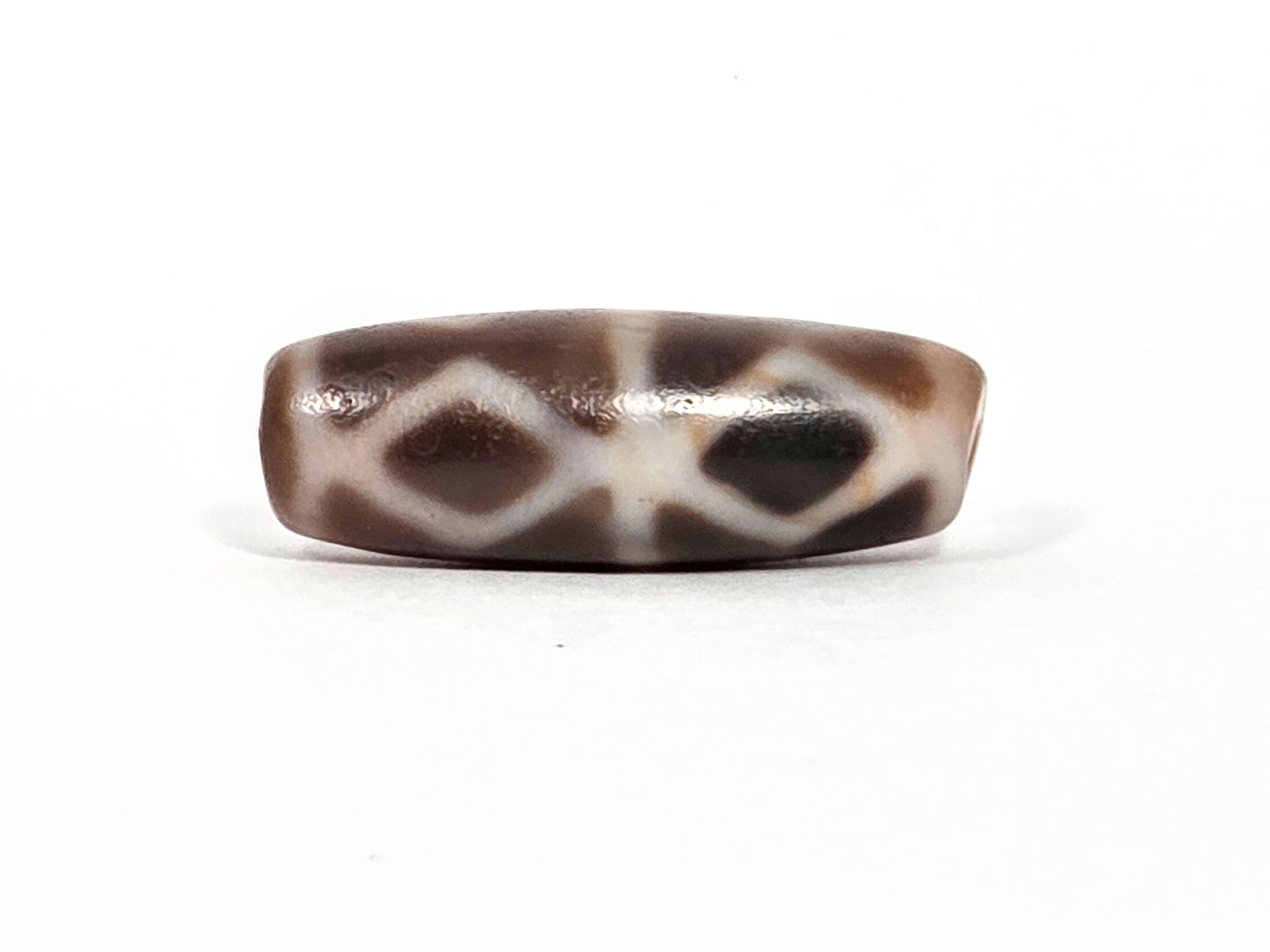 At-080926-6EDS2 antique Six Eye Diamond Spear dzi bead 33.0×11.5mm, Face A alternate angle showing diamond lattice and deeper warm brown toward right drill end, unretouched