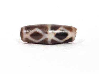 At-080926-6EDS2 antique Six Eye Diamond Spear dzi bead 33.0×11.5mm, Face A alternate angle showing diamond lattice and deeper warm brown toward right drill end, unretouched