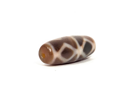 At-080926-6EDS2 antique Six Eye Diamond Spear dzi bead 33.0×11.5mm, opposite angled drill-end view showing warm translucent agate tip and diamond motif body, unretouched