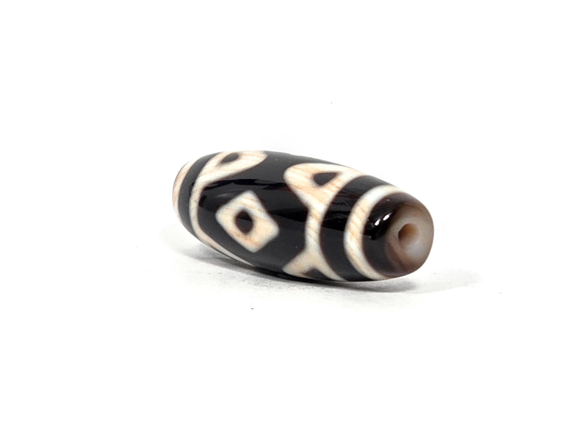 At-090126-3DETT antique three diamond eye tiger tooth dzi drill end view one warm brown cap unretouched